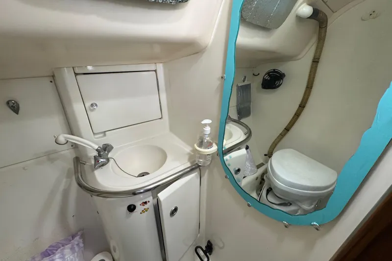 Slide: The Image of Compact bathroom in a 1994 Beneteau 40 sailboat with sink, mirror, and toilet. - 74