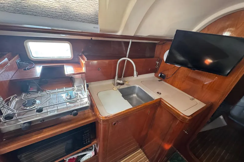 Slide: The Image of Galley view with Eno cooktop, double sink, and insignia mounted TV. - 79