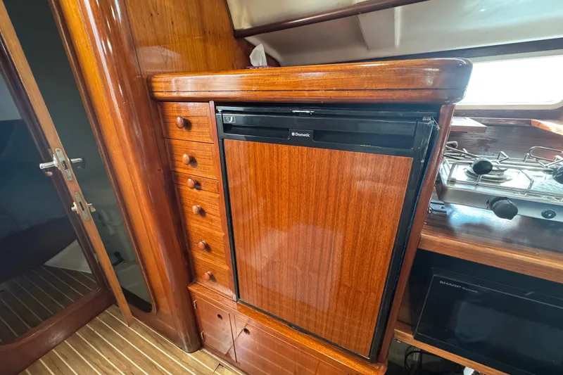 Slide: The Image of Interior of 1994 Beneteau 40 yacht with wooden cabinetry and compact kitchen appliances. - 84