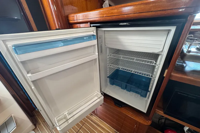 Slide: The Image of Open refrigerator inside a 1994 Beneteau 40 yacht, showcasing shelves and storage compartments. - 85