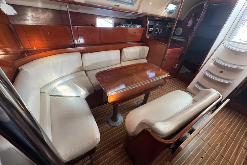 Slide: The Image of Interior of 1994 Beneteau 40 yacht with white seating and wooden table. - 90