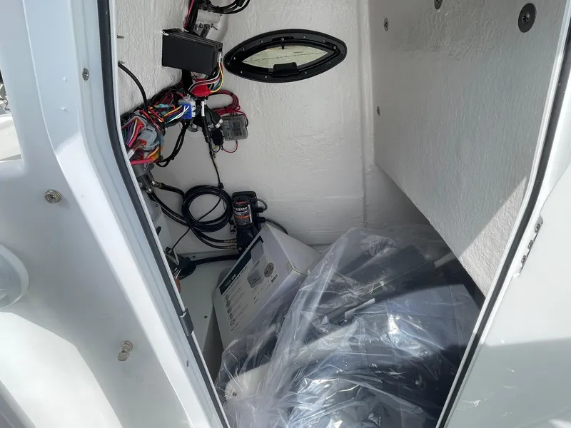Slide: The Image of Interior view of 2025 Sea Pro 222 Center Console boat's storage compartment with wiring and equipment. - 19