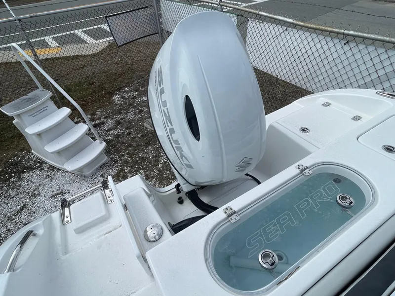 Slide: The Image of 2025 Sea Pro 222 Center Console boat with Suzuki outboard motor, docked near a fence. - 7