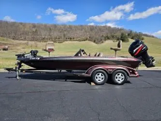 Slide: The Image of 2000 Ranger 520VX boat on trailer, parked outdoors with scenic hills in background. - 0