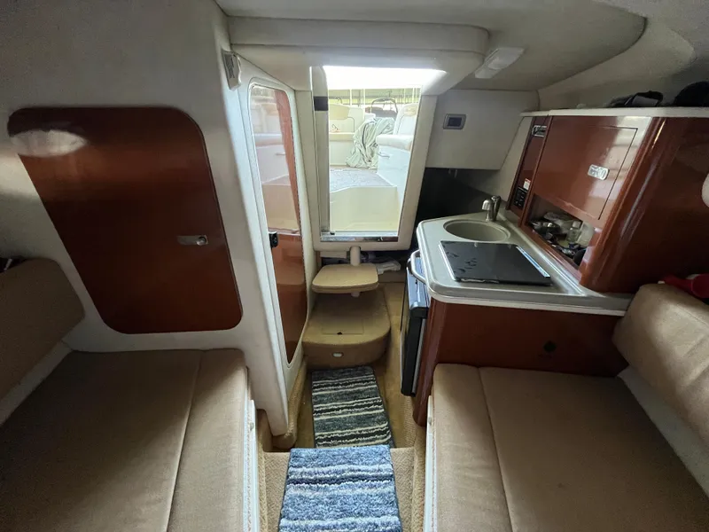 Slide: The Image of Interior of 2014 Sea Ray 240 Sundancer boat with kitchenette and seating area. - 10