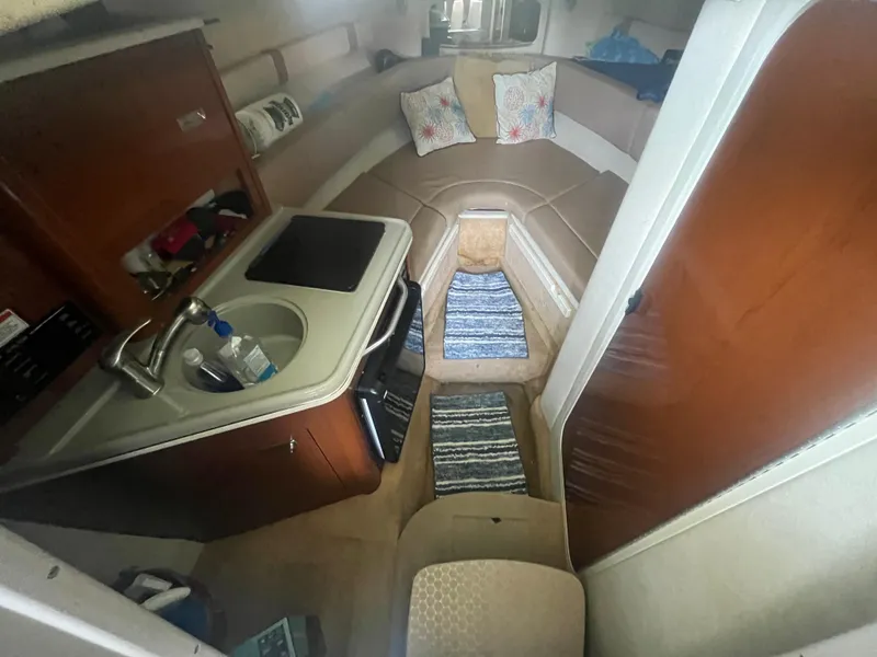 Slide: The Image of 2014 Sea Ray 240 Sundancer cabin interior with kitchenette and seating area. - 13