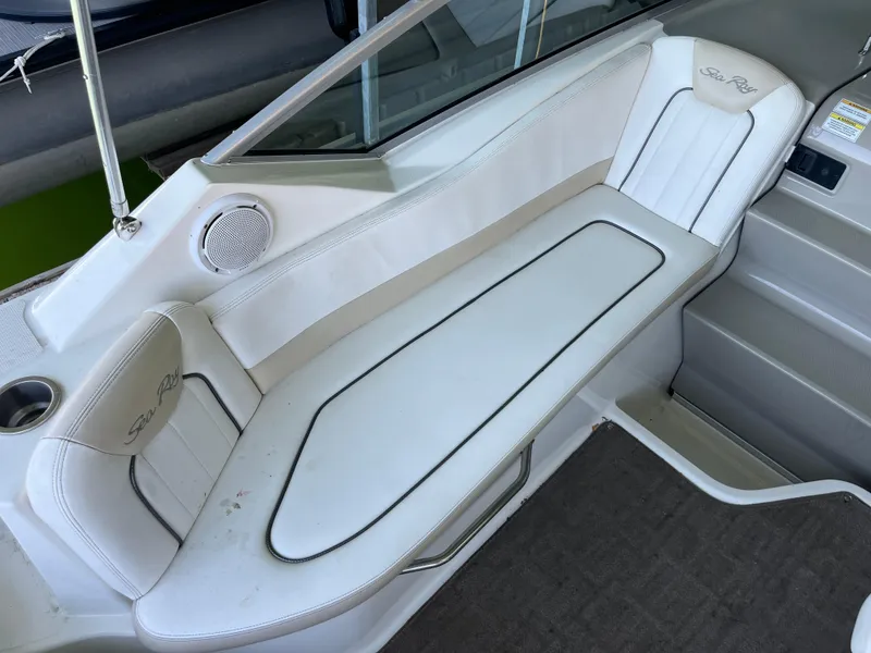 Slide: The Image of 2014 Sea Ray 240 Sundancer boat interior with white cushioned seating. - 16