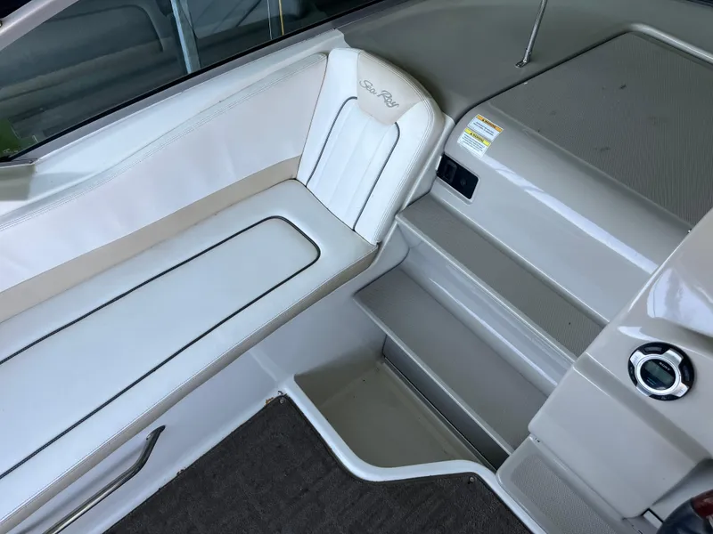 Slide: The Image of Interior seating of 2014 Sea Ray 240 Sundancer boat, featuring white upholstery and sleek design. - 17