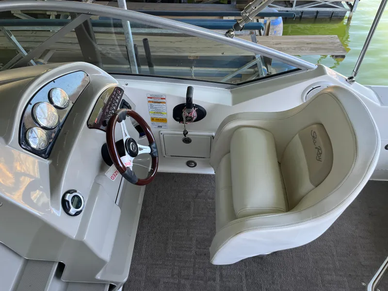 Slide: The Image of 2014 Sea Ray 240 Sundancer helm with steering wheel and comfortable seating. - 19