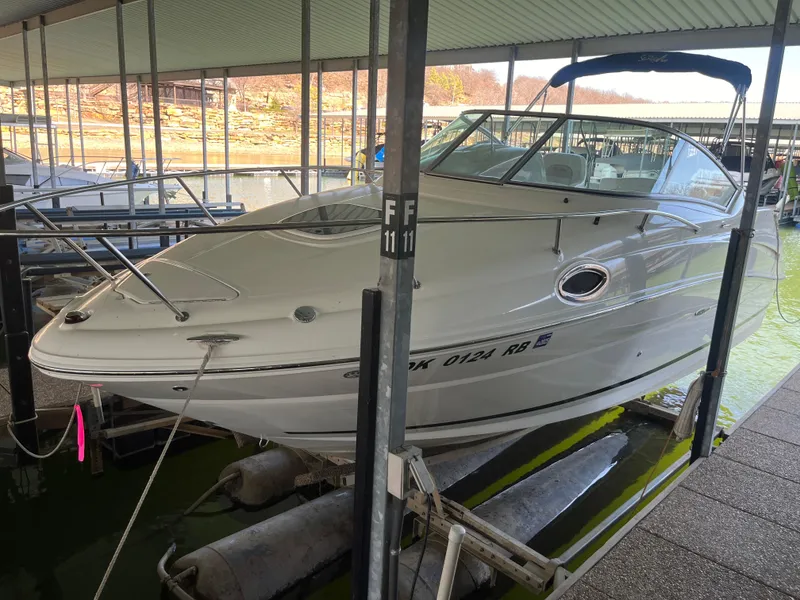 Slide: The Image of 2014 Sea Ray 240 Sundancer boat docked in a covered marina. - 2