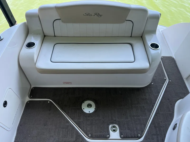 Slide: The Image of 2014 Sea Ray 240 Sundancer boat seating area with cup holders and carpeted floor. - 26