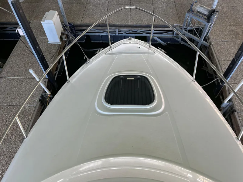 Slide: The Image of 2014 Sea Ray 240 Sundancer boat deck with hatch, docked in a marina. - 7