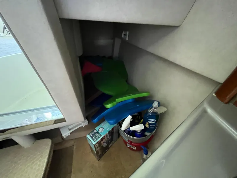 Slide: The Image of Interior of 2014 Sea Ray 240 Sundancer with cleaning supplies and colorful cushions. - 9
