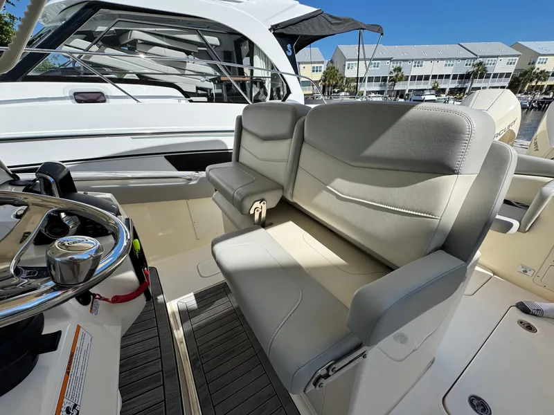 Slide: The Image of 2023 Scout 305 LXF boat interior with plush seating and steering console. - 11