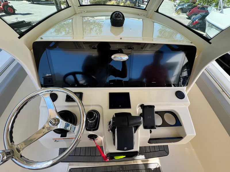 Slide: The Image of 2023 Scout 305 LXF boat dashboard with steering wheel and control panel. - 12
