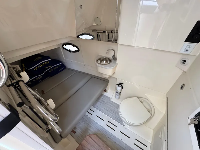 Slide: The Image of 2023 Scout 305 LXF boat interior with seating, sink, and toilet. - 19