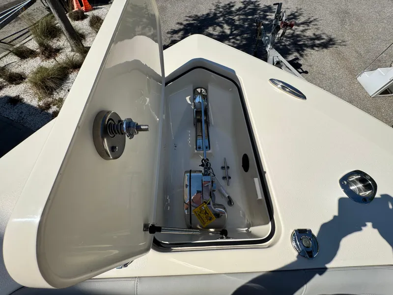 Slide: The Image of 2023 Scout 305 LXF boat anchor compartment with open hatch, showcasing storage details. - 21