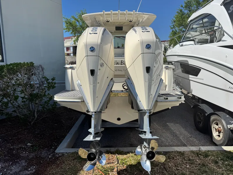 Slide: The Image of 2023 Scout 305 LXF boat with dual outboard engines, parked outdoors. - 6