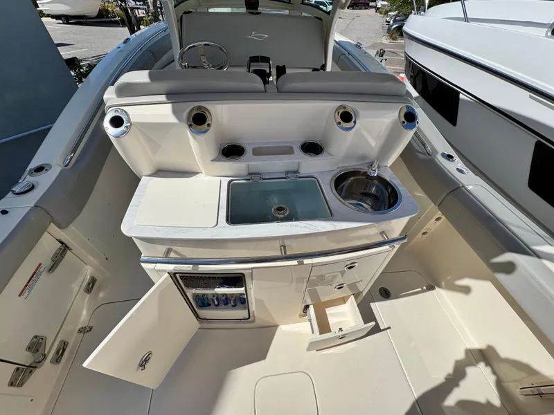 Slide: The Image of 2023 Scout 305 LXF boat interior with sink, storage, and seating area. - 9
