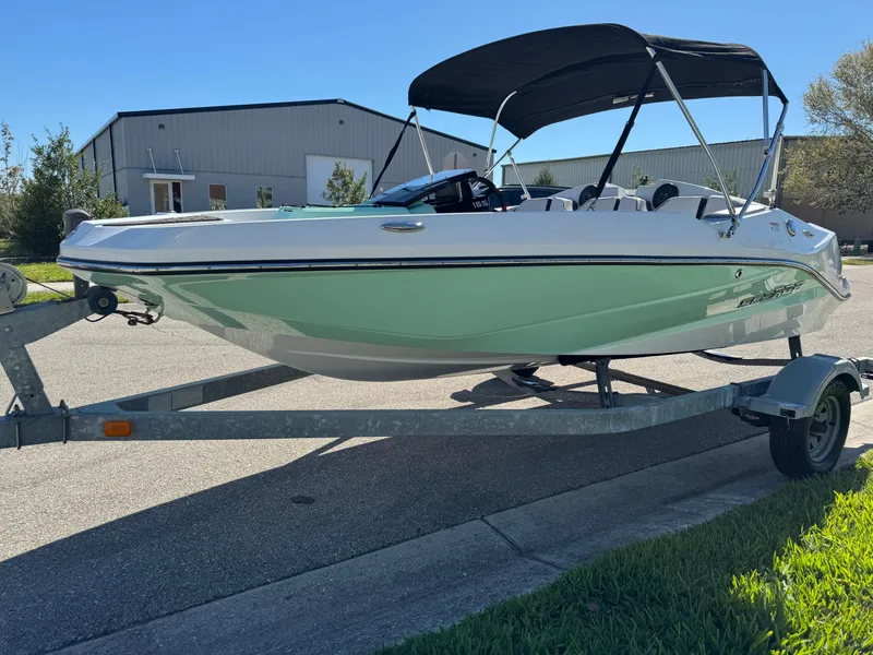 Slide: The Image of 2022 Scarab 165 ID boat on trailer with canopy, parked outdoors. - 12