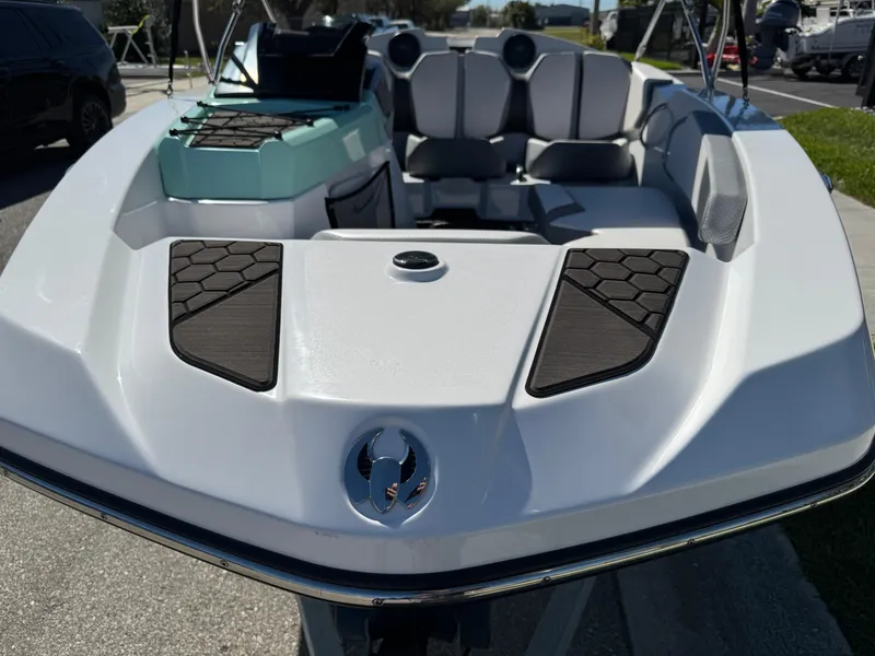 Slide: The Image of 2022 Scarab 165 ID boat, white exterior, black accents, modern seating, parked outdoors. - 14