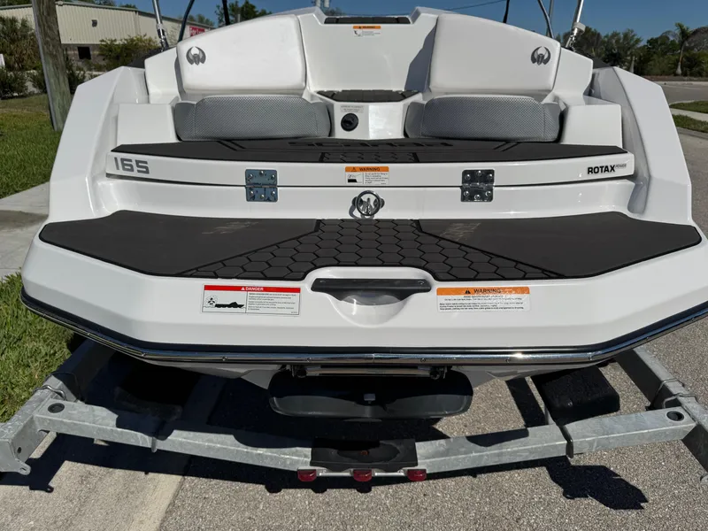 Slide: The Image of 2022 Scarab 165 ID boat rear view on trailer, featuring Rotax engine. - 4
