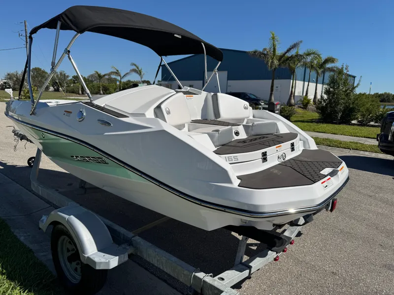 Slide: The Image of 2022 Scarab 165 ID boat on trailer, parked outdoors under clear blue sky. - 6