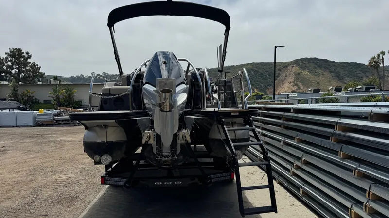 Slide: The Image of 2023 Barletta Lusso 23UC pontoon boat, rear view, parked outdoors with scenic background. - 10