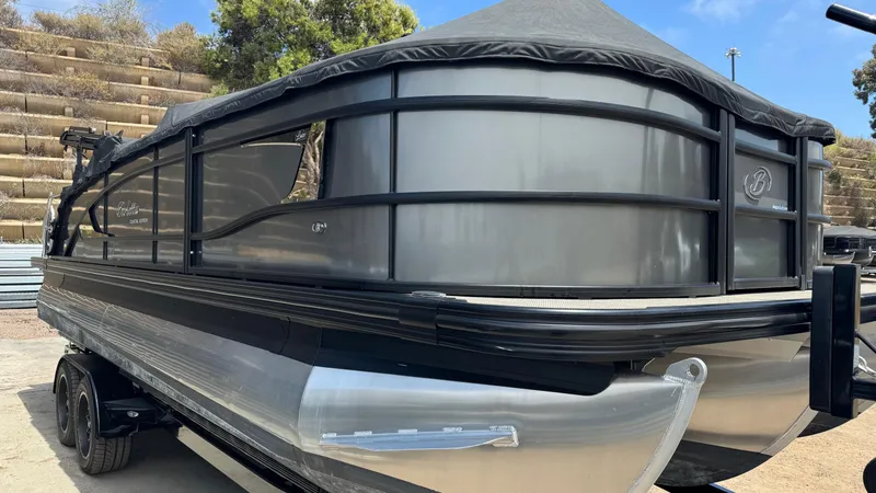Slide: The Image of 2023 Barletta Lusso 23UC pontoon boat on trailer, sleek design, black and silver finish. - 12