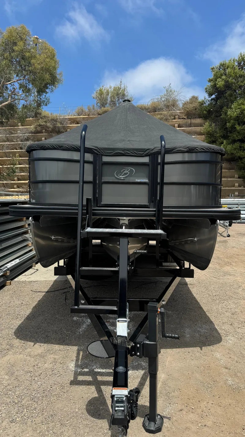 Slide: The Image of 2023 Barletta Lusso 23UC pontoon boat on trailer, parked outdoors. - 15