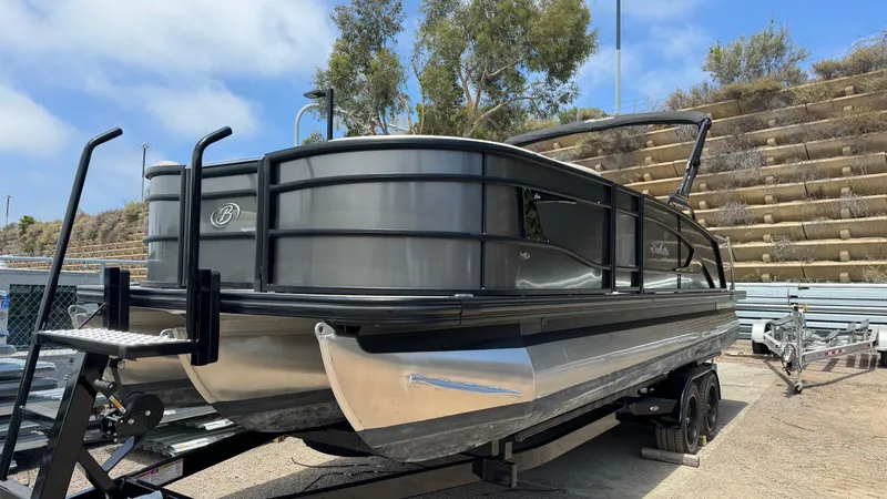 Slide: The Image of 2023 Barletta Lusso 23UC pontoon boat on trailer, parked outdoors. - 5
