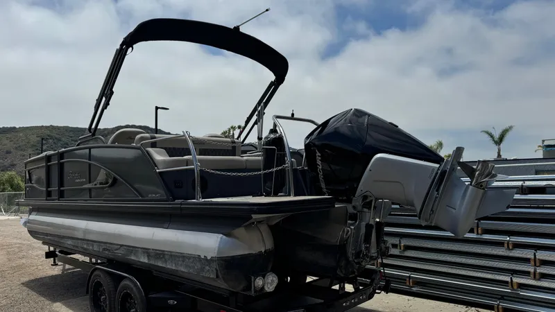 Slide: The Image of 2023 Barletta Lusso 23UC pontoon boat on trailer, outdoor setting. - 7