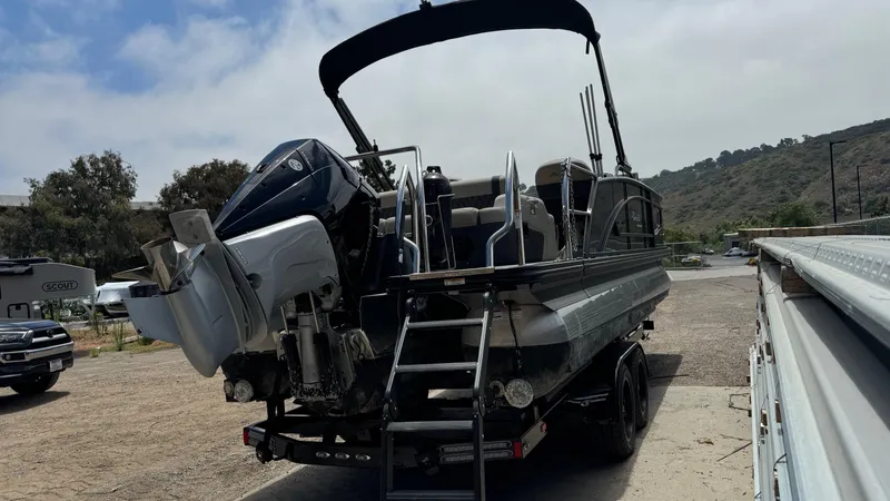 Slide: The Image of 2023 Barletta Lusso 23UC pontoon boat on trailer, parked outdoors. - 8