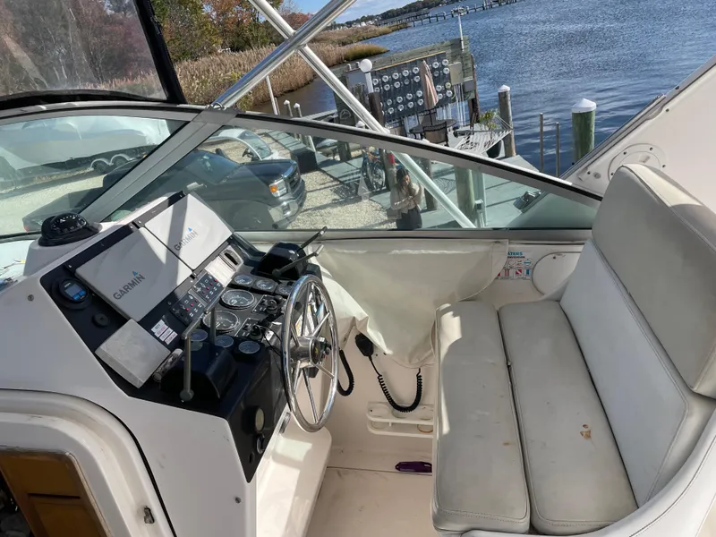 Slide: The Image of 1995 Bertram 30 Moppie boat cockpit with steering wheel and control panel, dockside view. - 3