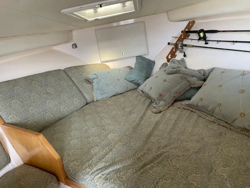 Slide: The Image of Cozy cabin interior of 1995 Bertram 30 Moppie with patterned cushions and fishing rods. - 8