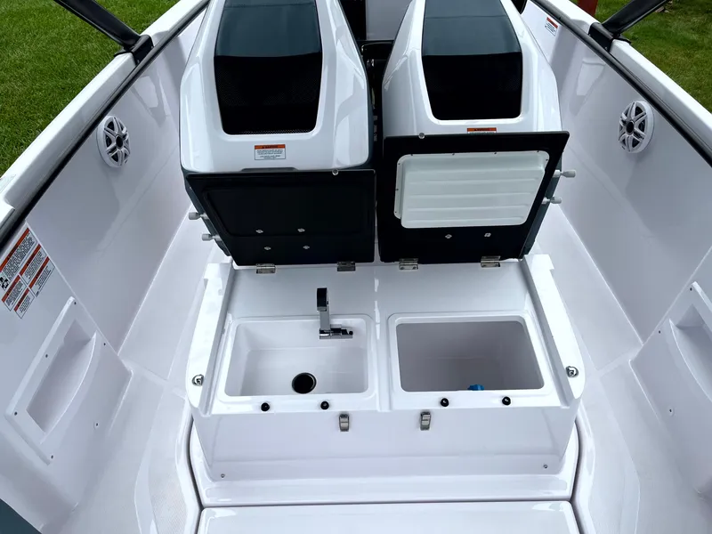 Slide: The Image of 2024 Axopar 22 boat interior with dual seats, sink, and storage compartments. - 24