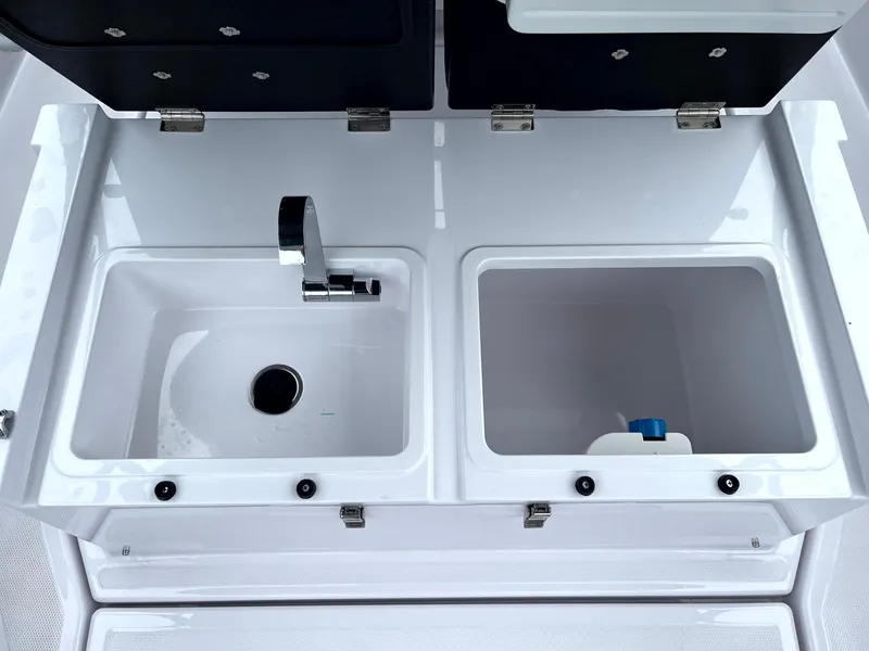 Slide: The Image of 2024 Axopar 22 boat sink and storage compartment, featuring sleek design and modern fixtures. - 25