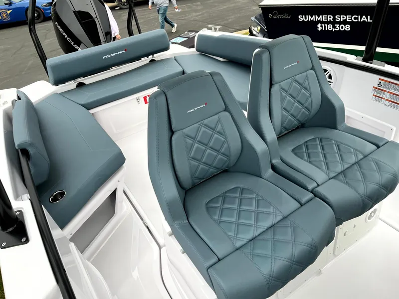 Slide: The Image of 2024 Axopar 22 boat interior with blue quilted seats, summer special price displayed. - 3