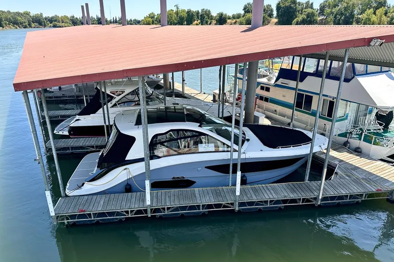 The Image of 2025 Sea Ray Sundancer 370 docked under a covered marina slip. - 0