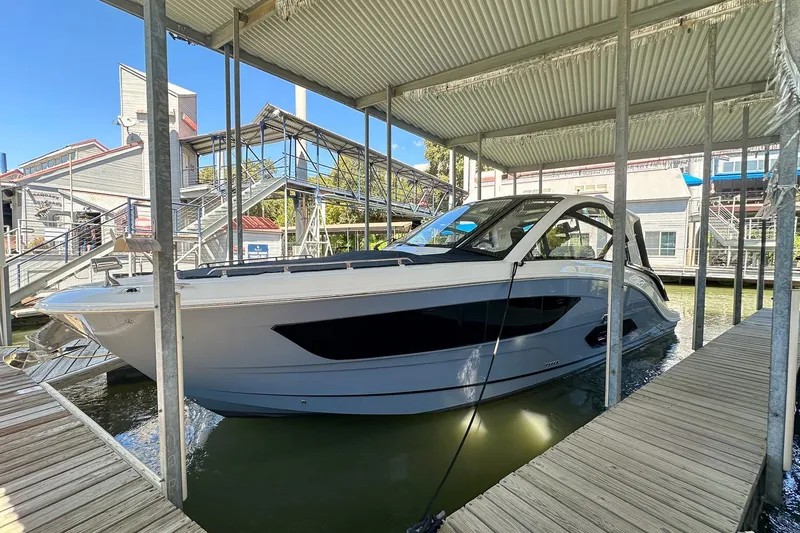 Slide: The Image of 2025 Sea Ray Sundancer 370 docked under a covered marina. - 1