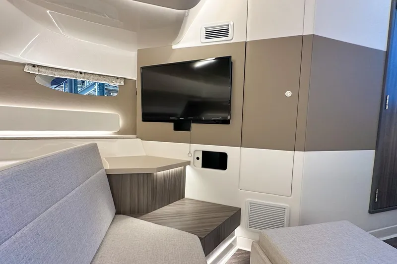 Slide: The Image of Interior of 2025 Sea Ray Sundancer 370 with modern seating and wall-mounted TV. - 26