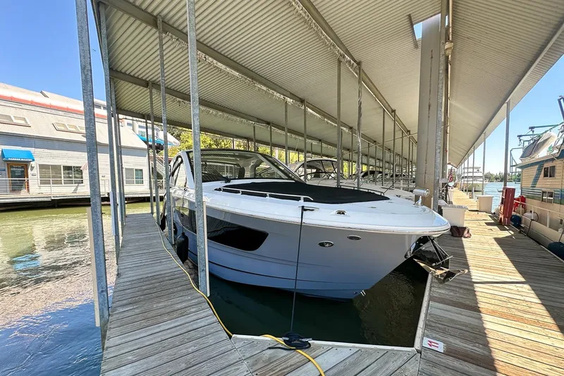 Slide: The Image of 2025 Sea Ray Sundancer 370 docked in a covered marina slip. - 3