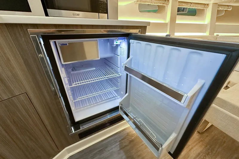 Slide: The Image of Open refrigerator inside 2025 Sea Ray Sundancer 370 yacht, showcasing modern interior design. - 30