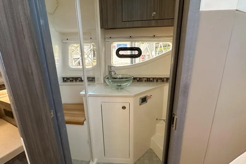 Slide: The Image of Interior of 2025 Sea Ray Sundancer 370, featuring a modern bathroom with glass sink. - 32