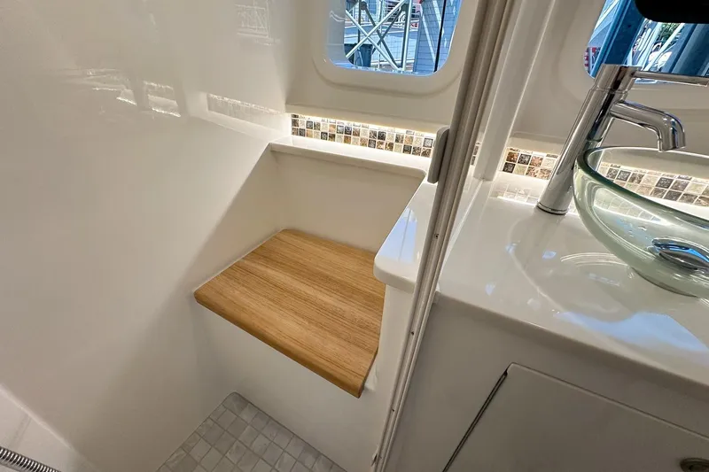 Slide: The Image of 2025 Sea Ray Sundancer 370 bathroom with modern sink and wooden seat. - 35