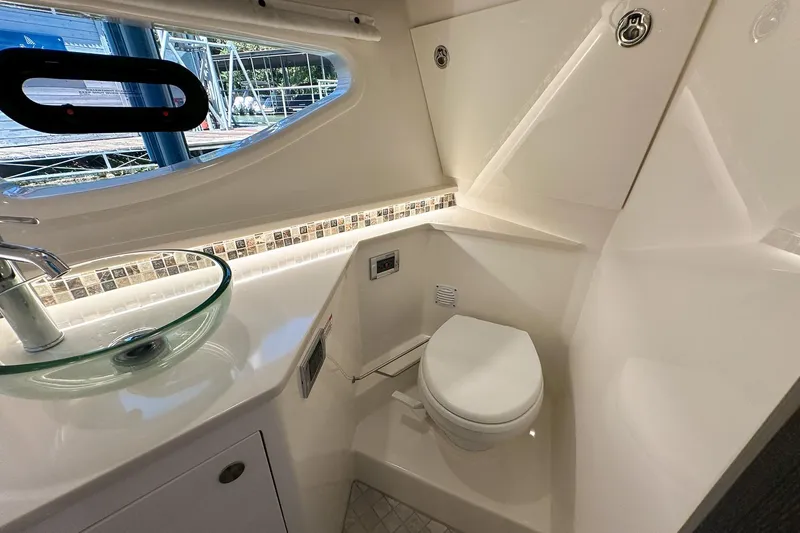 Slide: The Image of 2025 Sea Ray Sundancer 370 bathroom with modern sink and toilet, featuring sleek design. - 37