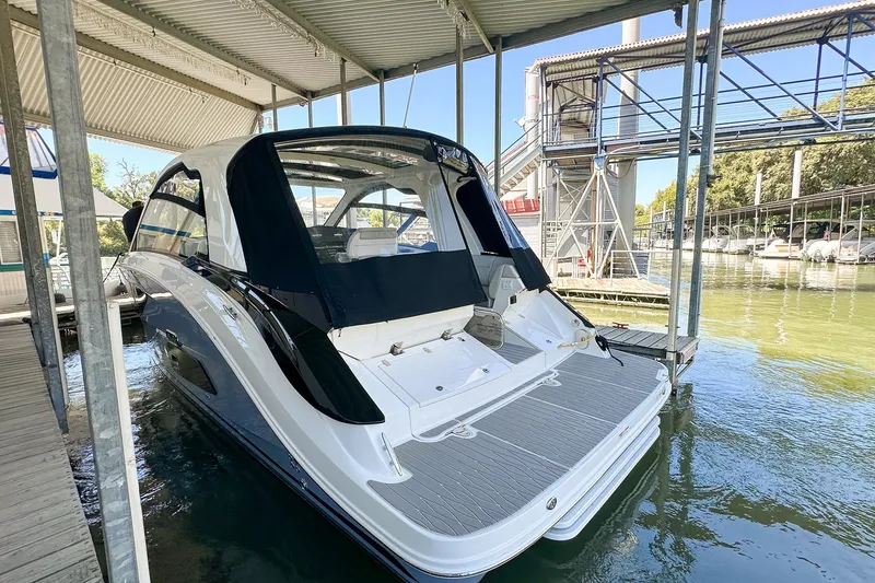Slide: The Image of 2025 Sea Ray Sundancer 370 docked under a covered marina, showcasing sleek design. - 4