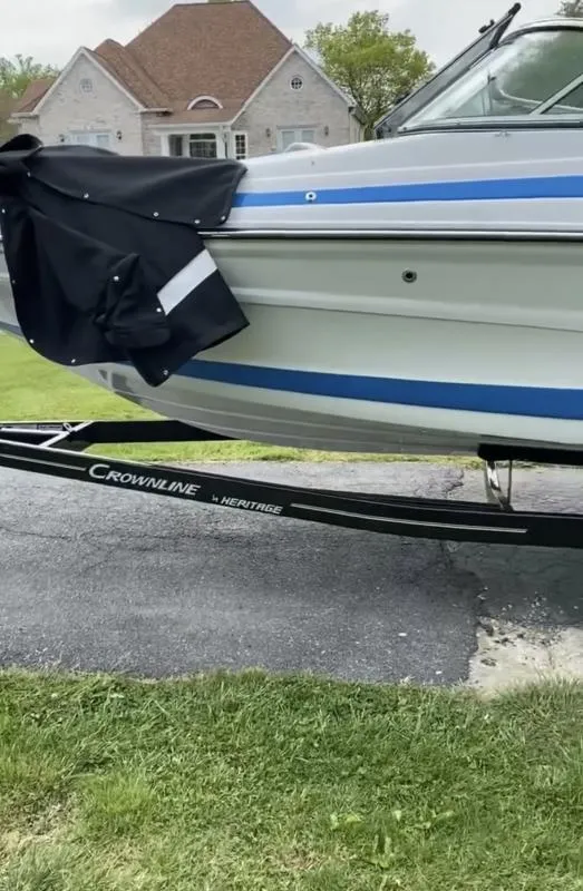 Slide: The Image of 2023 Crownline 240 SS boat on trailer, parked in residential area. - 10