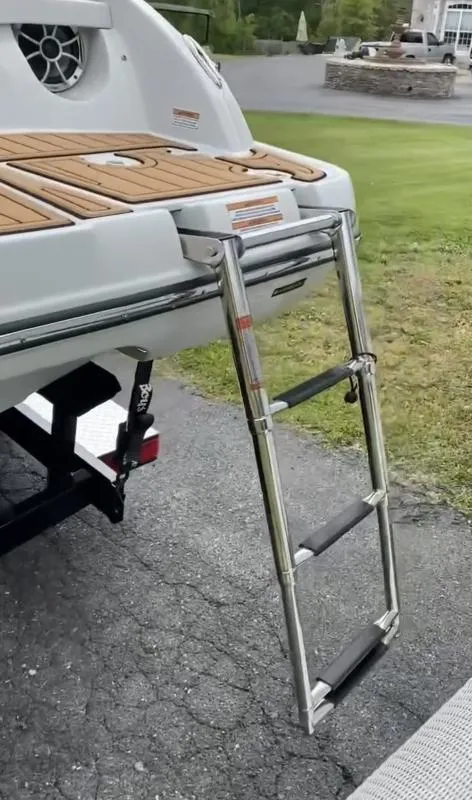 Slide: The Image of 2023 Crownline 240 SS boat with extended swim ladder on a trailer. - 13