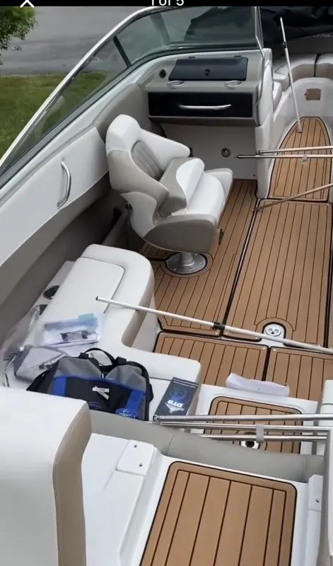 Slide: The Image of 2023 Crownline 240 SS boat interior with tan flooring and white seating. - 17
